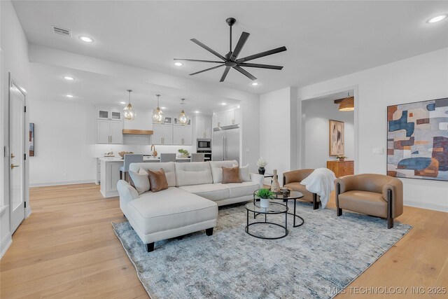 living room featuring ceiling fan and light wood-type flooring