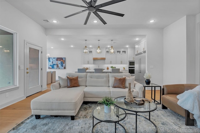 living room with ceiling fan and light hardwood / wood-style floors