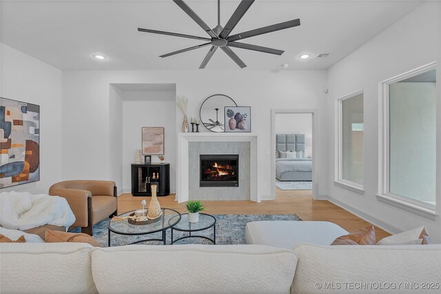 living room featuring ceiling fan and light hardwood / wood-style flooring