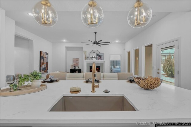 kitchen with pendant lighting, an inviting chandelier, and light stone counters