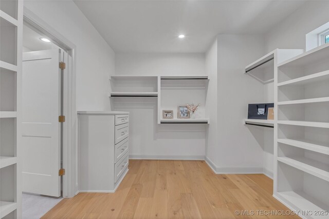 walk in closet with light hardwood / wood-style flooring