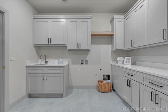 clothes washing area with cabinets, electric dryer hookup, sink, and hookup for a washing machine