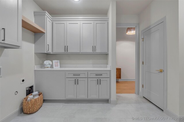 washroom featuring electric dryer hookup and cabinets