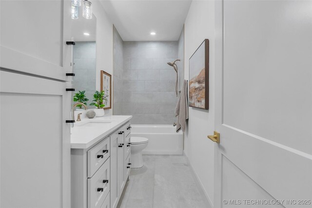 full bathroom featuring toilet, tiled shower / bath, and vanity