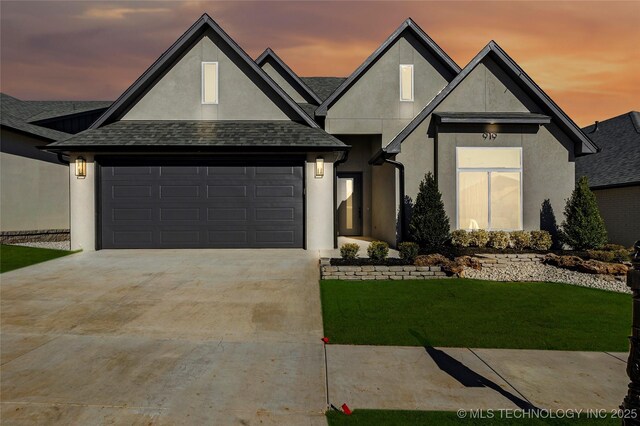 view of front of property with a yard and a garage