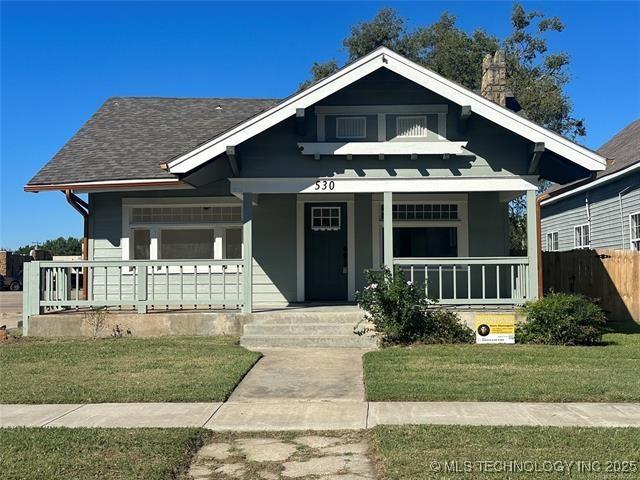 bungalow-style home with a porch and a front lawn