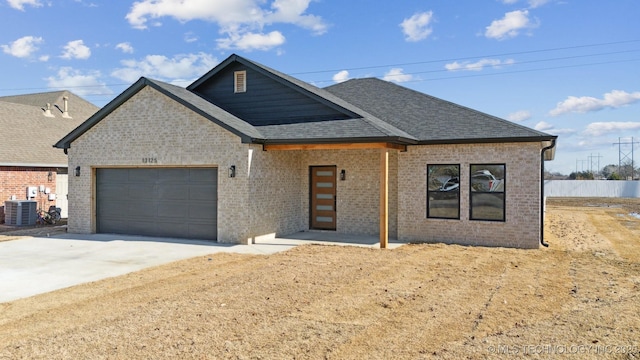 view of front of home with central air condition unit and a garage