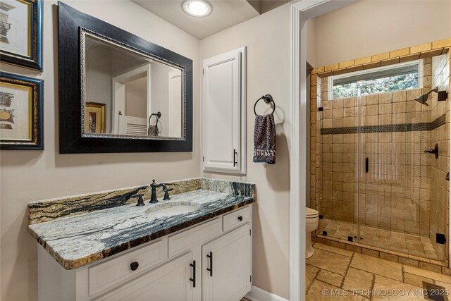 bathroom with toilet, an enclosed shower, and vanity