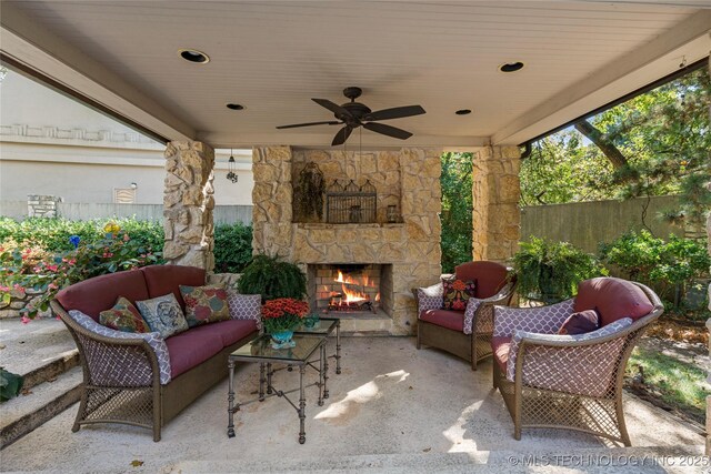 view of patio with ceiling fan and an outdoor living space with a fireplace