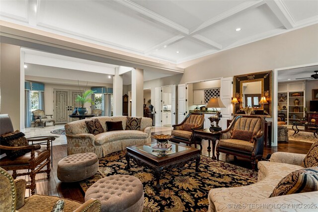 living room with beamed ceiling, ceiling fan, hardwood / wood-style floors, coffered ceiling, and crown molding