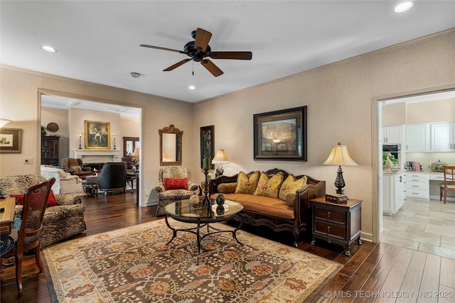 living room featuring ceiling fan and crown molding