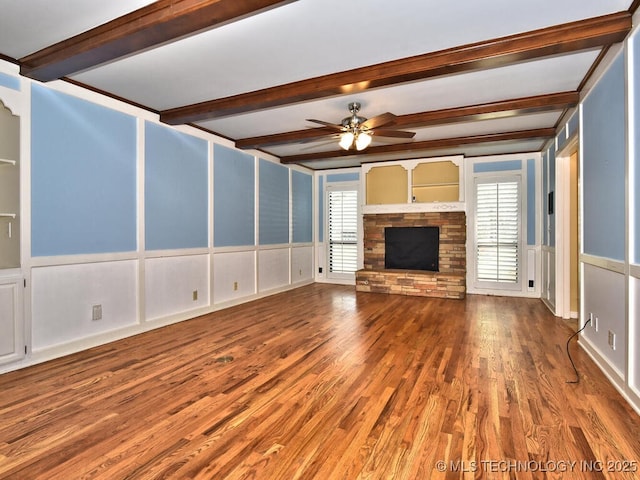 unfurnished living room with ceiling fan, a wealth of natural light, a fireplace, and hardwood / wood-style flooring