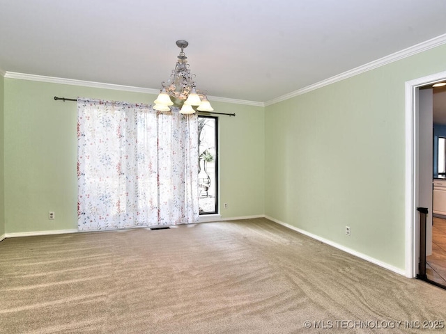 spare room with carpet floors, crown molding, and a chandelier