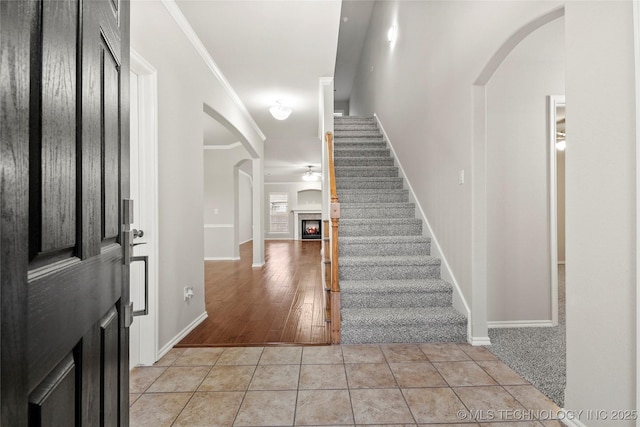 entryway featuring ornamental molding, ceiling fan, and light tile patterned floors