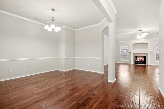 interior space featuring ceiling fan with notable chandelier, ornamental molding, and dark hardwood / wood-style flooring