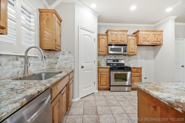 kitchen featuring stainless steel appliances, light stone countertops, decorative backsplash, and sink