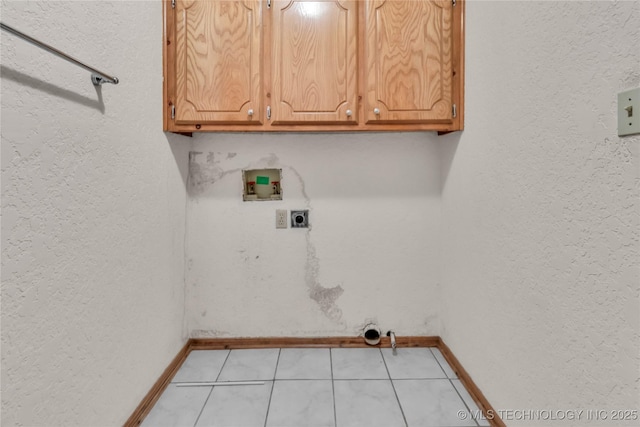 washroom featuring electric dryer hookup, hookup for a washing machine, cabinets, and light tile patterned floors