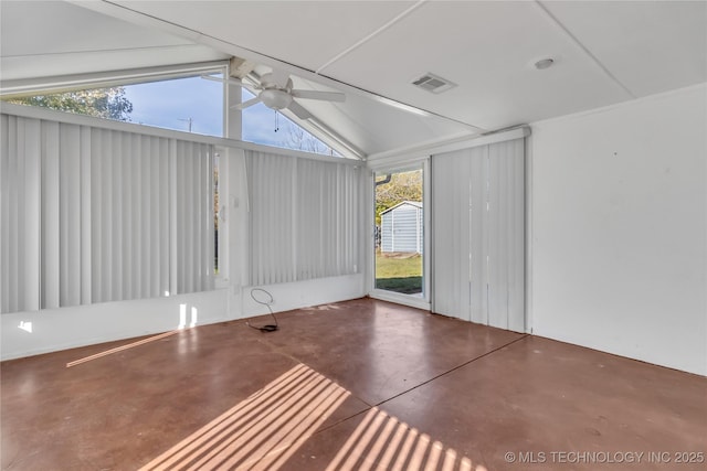 empty room featuring lofted ceiling, ceiling fan, concrete flooring, and a wealth of natural light