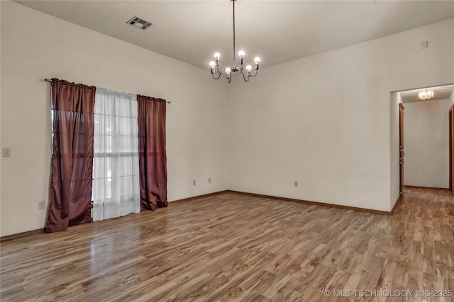 unfurnished room featuring light hardwood / wood-style floors and a chandelier