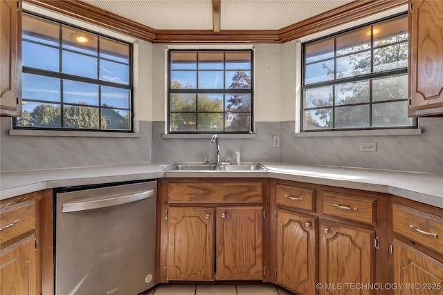 kitchen featuring stainless steel dishwasher, backsplash, light tile patterned floors, and sink