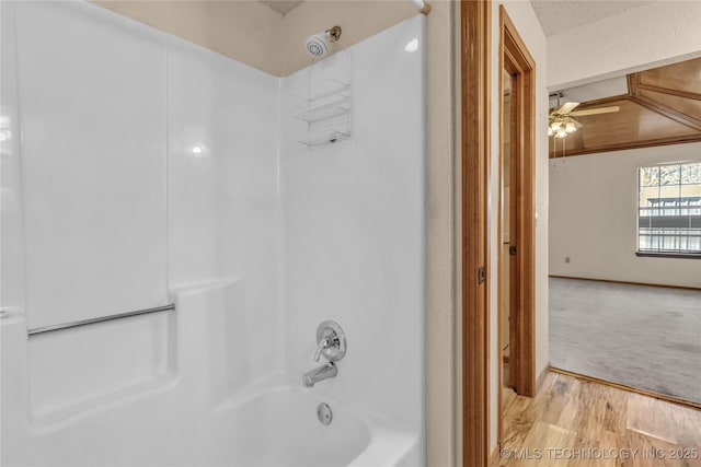 bathroom with ceiling fan, shower / bathtub combination, and hardwood / wood-style floors