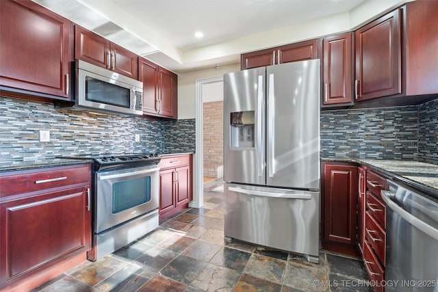 kitchen with backsplash, dark stone counters, and appliances with stainless steel finishes