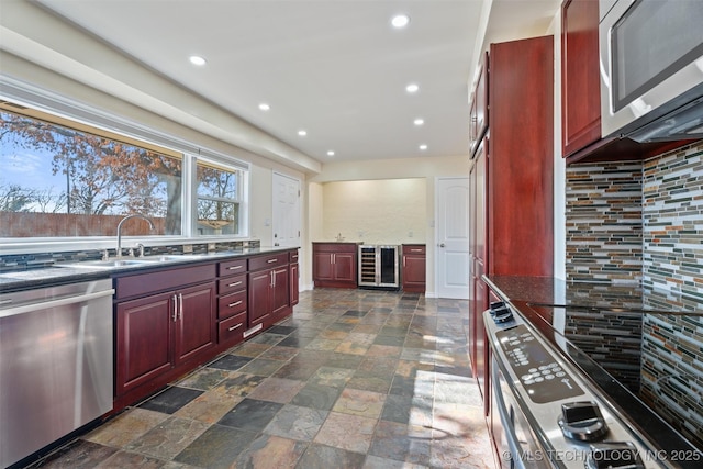 kitchen featuring stainless steel appliances, beverage cooler, and sink