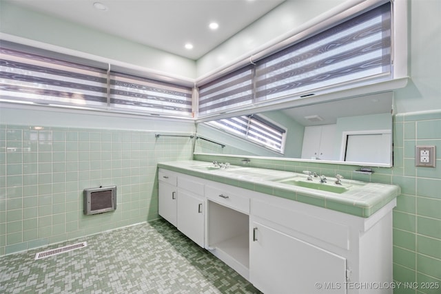 bathroom featuring tile walls, tile patterned floors, and vanity