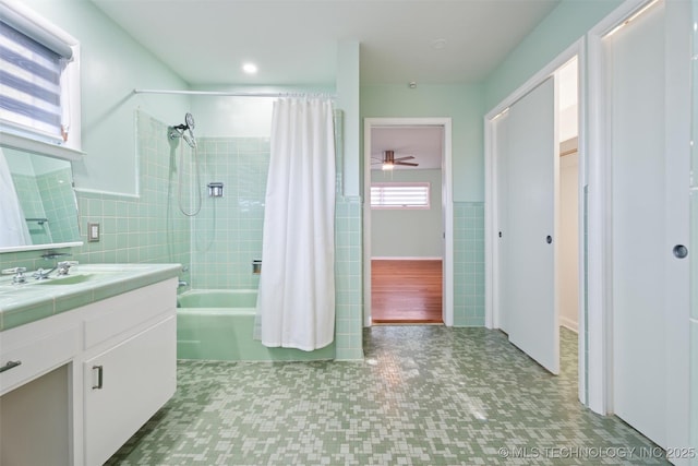 bathroom featuring shower / tub combo, vanity, tile walls, and ceiling fan