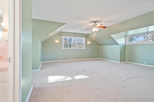 bonus room with carpet flooring, a textured ceiling, ceiling fan, and vaulted ceiling