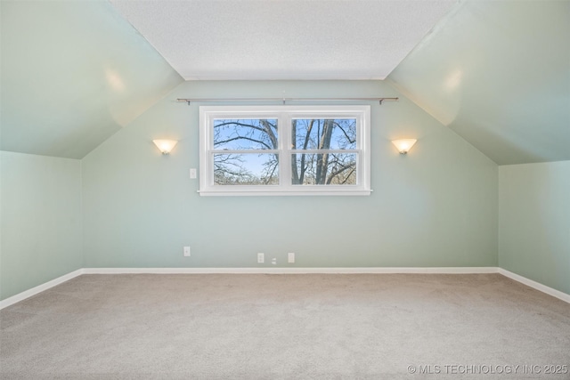 additional living space with a textured ceiling, carpet floors, and vaulted ceiling