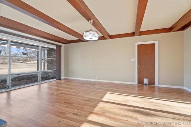 unfurnished room with beamed ceiling and hardwood / wood-style floors