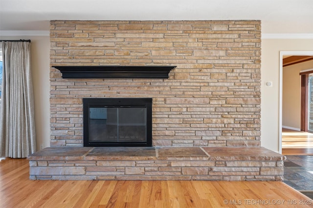 interior details with ornamental molding, a fireplace, and wood-type flooring