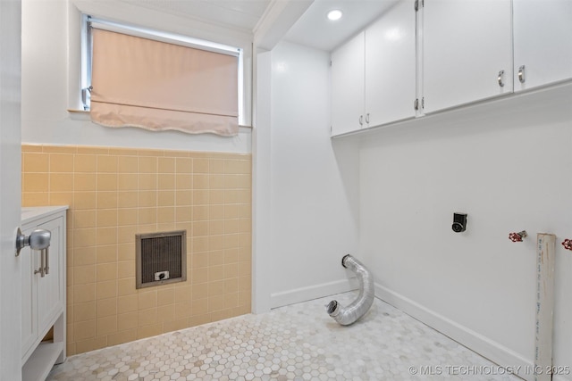 laundry area featuring tile walls, cabinets, and tile patterned floors