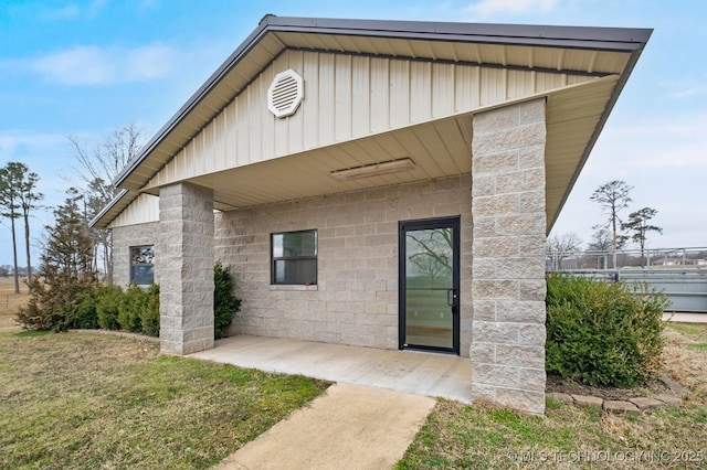 property entrance with a lawn and a patio area