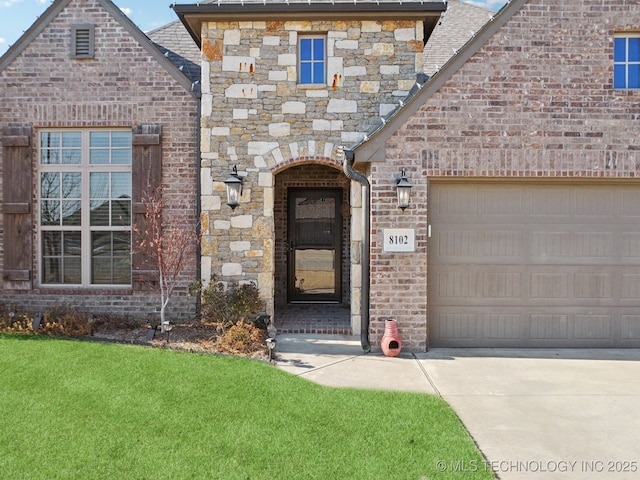 entrance to property featuring a garage and a lawn