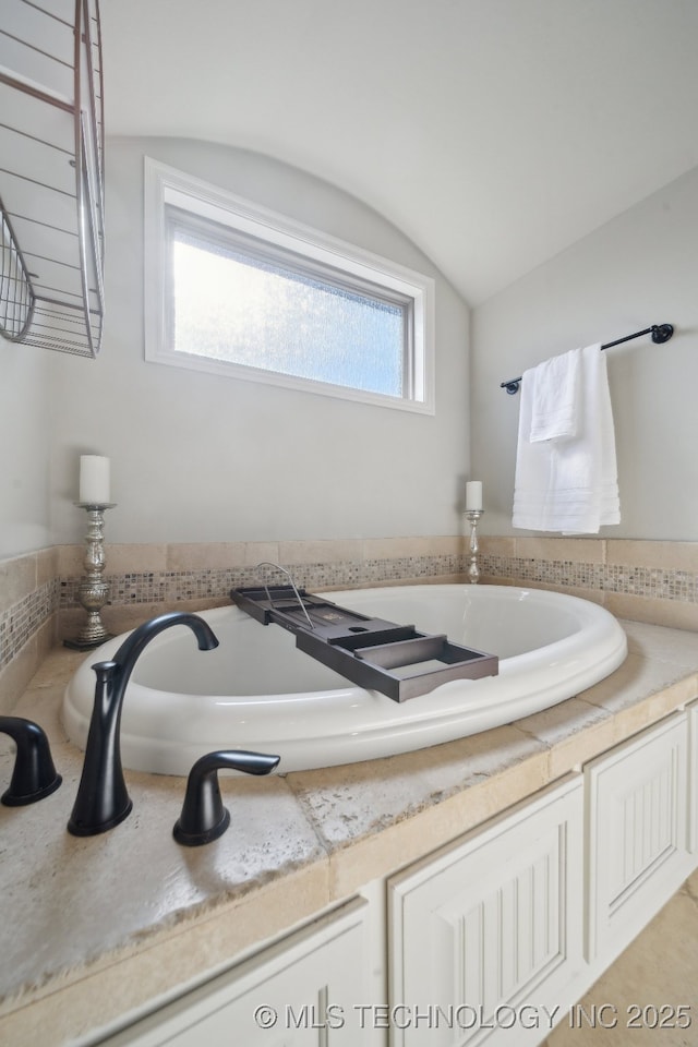 bathroom with lofted ceiling and plenty of natural light