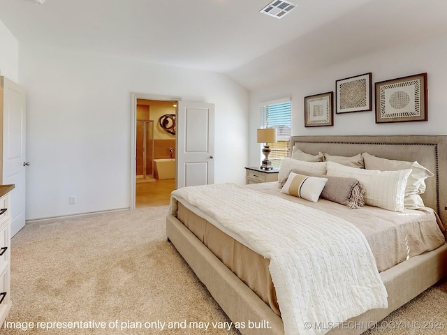 bedroom with light colored carpet, ensuite bathroom, and vaulted ceiling