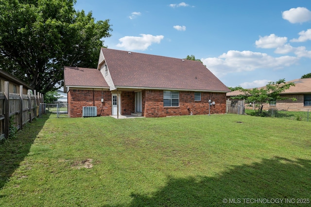 back of property with central air condition unit and a yard