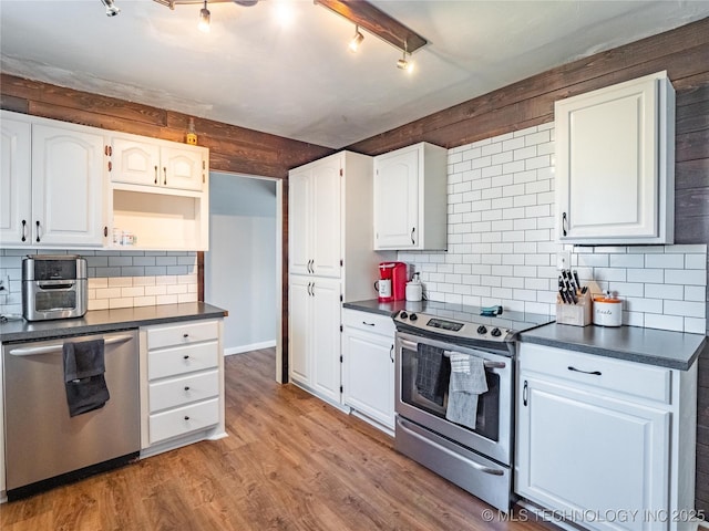 kitchen featuring white cabinetry, tasteful backsplash, light hardwood / wood-style floors, track lighting, and appliances with stainless steel finishes