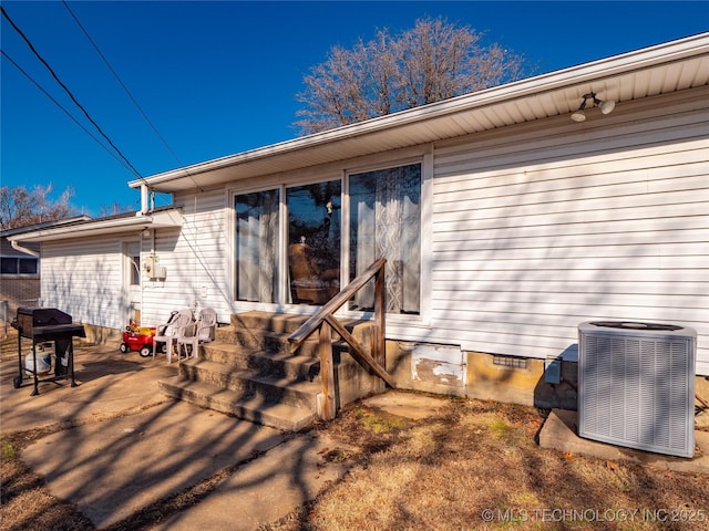 rear view of property with a patio and central AC