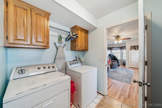 laundry room featuring light wood-type flooring, cabinets, ceiling fan, and washer and clothes dryer