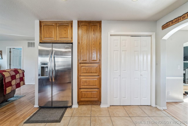 kitchen featuring light tile patterned flooring and stainless steel fridge