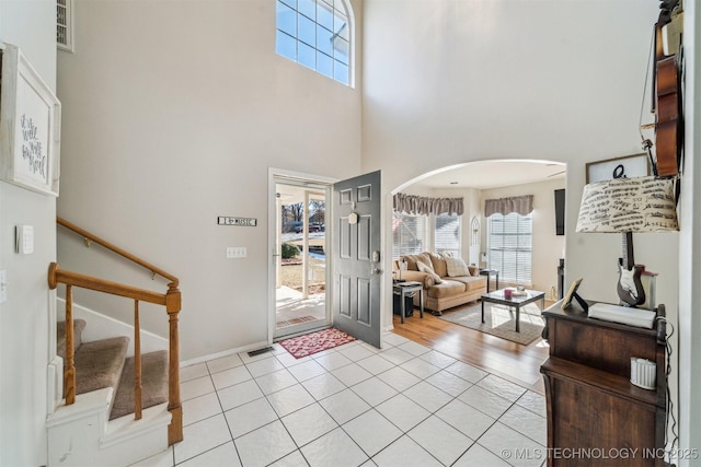 entryway with a high ceiling and light tile patterned flooring