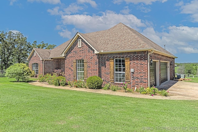 view of front facade with a garage, central air condition unit, and a front lawn