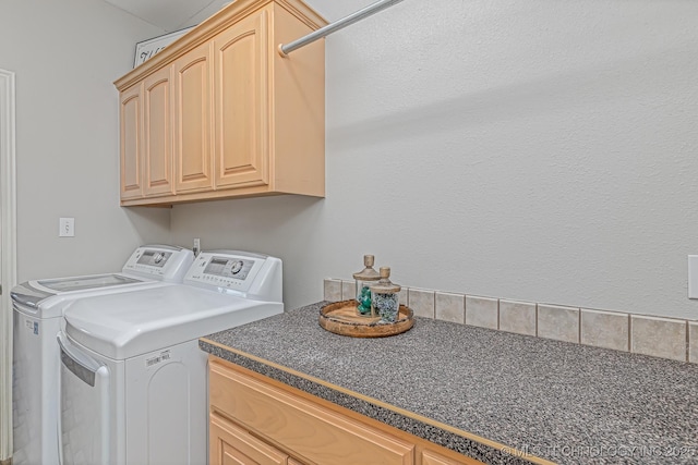 laundry area with washing machine and clothes dryer and cabinets