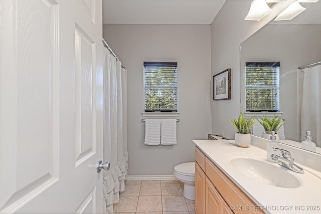 bathroom with toilet, vanity, and tile patterned floors