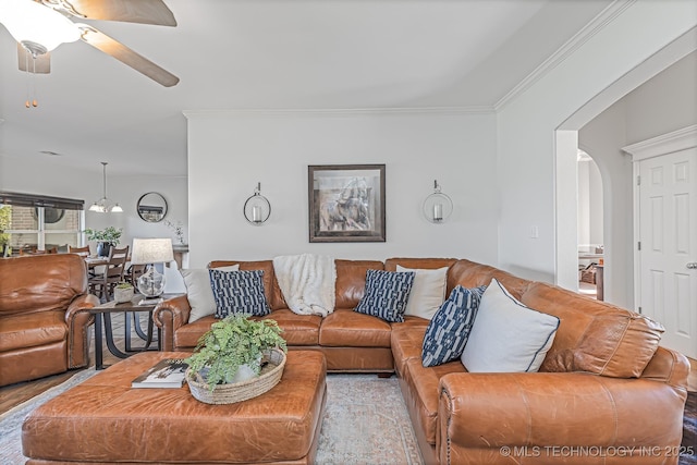 living room with ceiling fan and crown molding