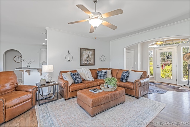 living room with crown molding, ceiling fan, and light hardwood / wood-style flooring