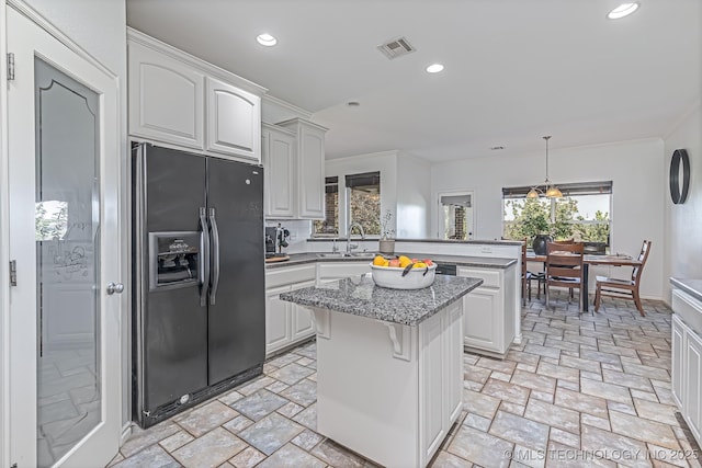 kitchen with black fridge with ice dispenser, white cabinets, a center island, kitchen peninsula, and pendant lighting